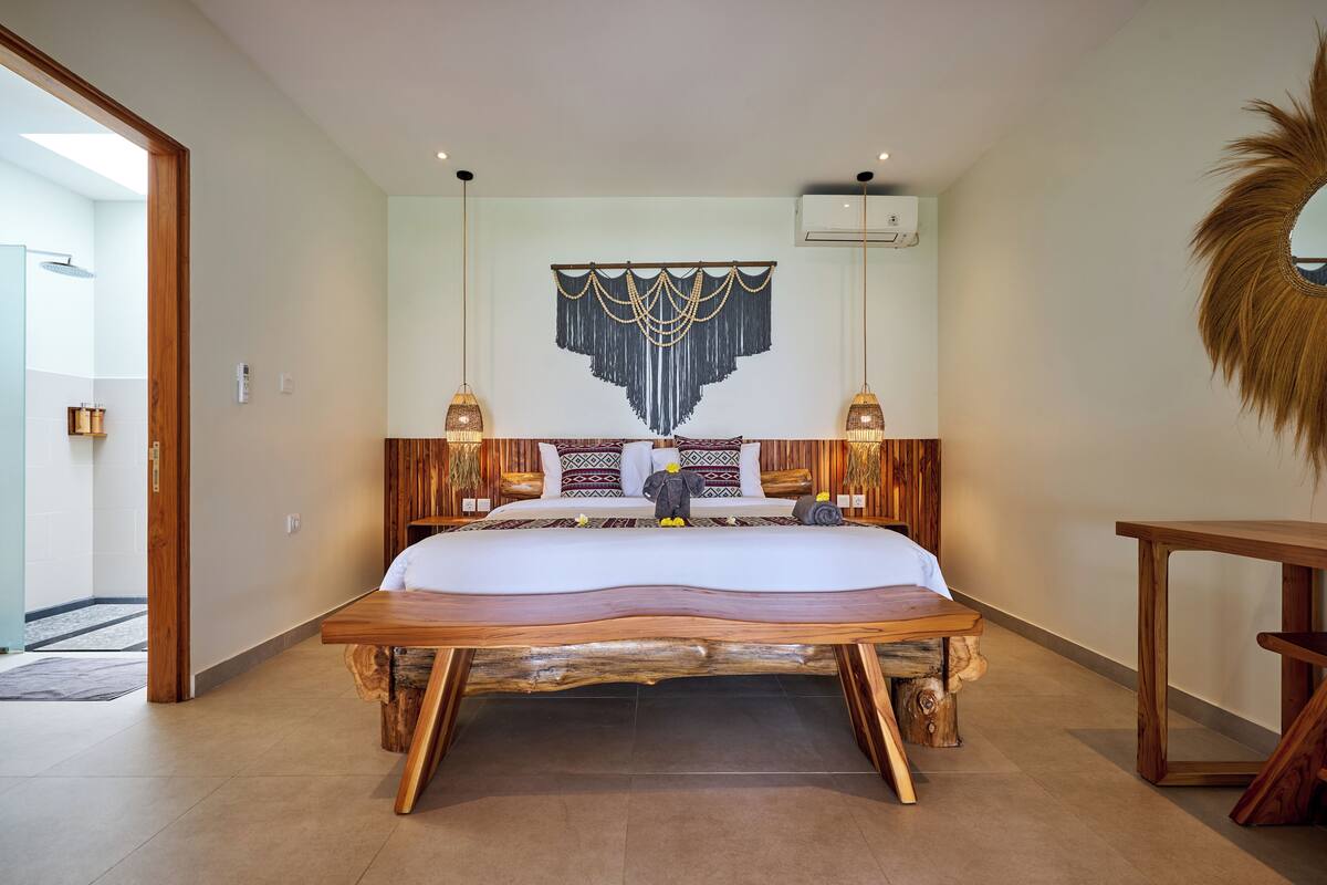Ein geräumiges Schlafzimmer mit einem großen Bett, einem Holzkopfende und einer dekorativen Wandgestalt.