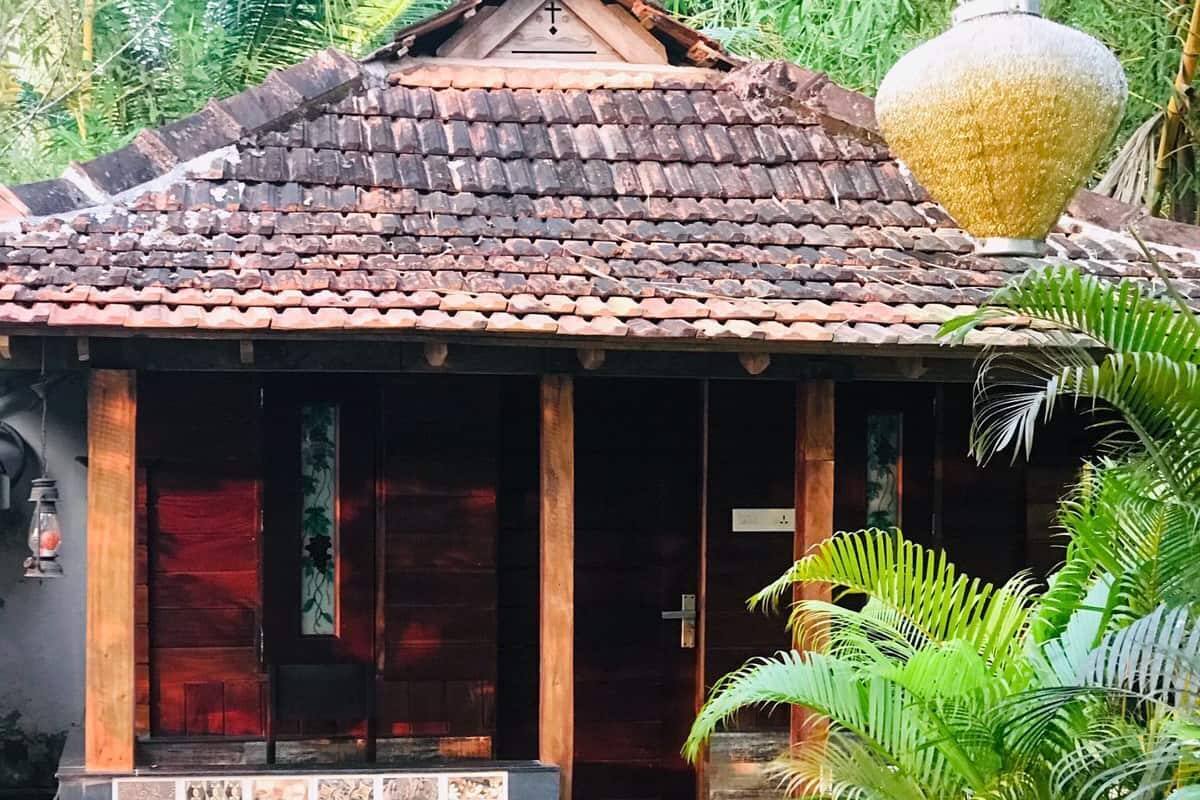 A small, traditional house with a tiled roof and a wooden porch.