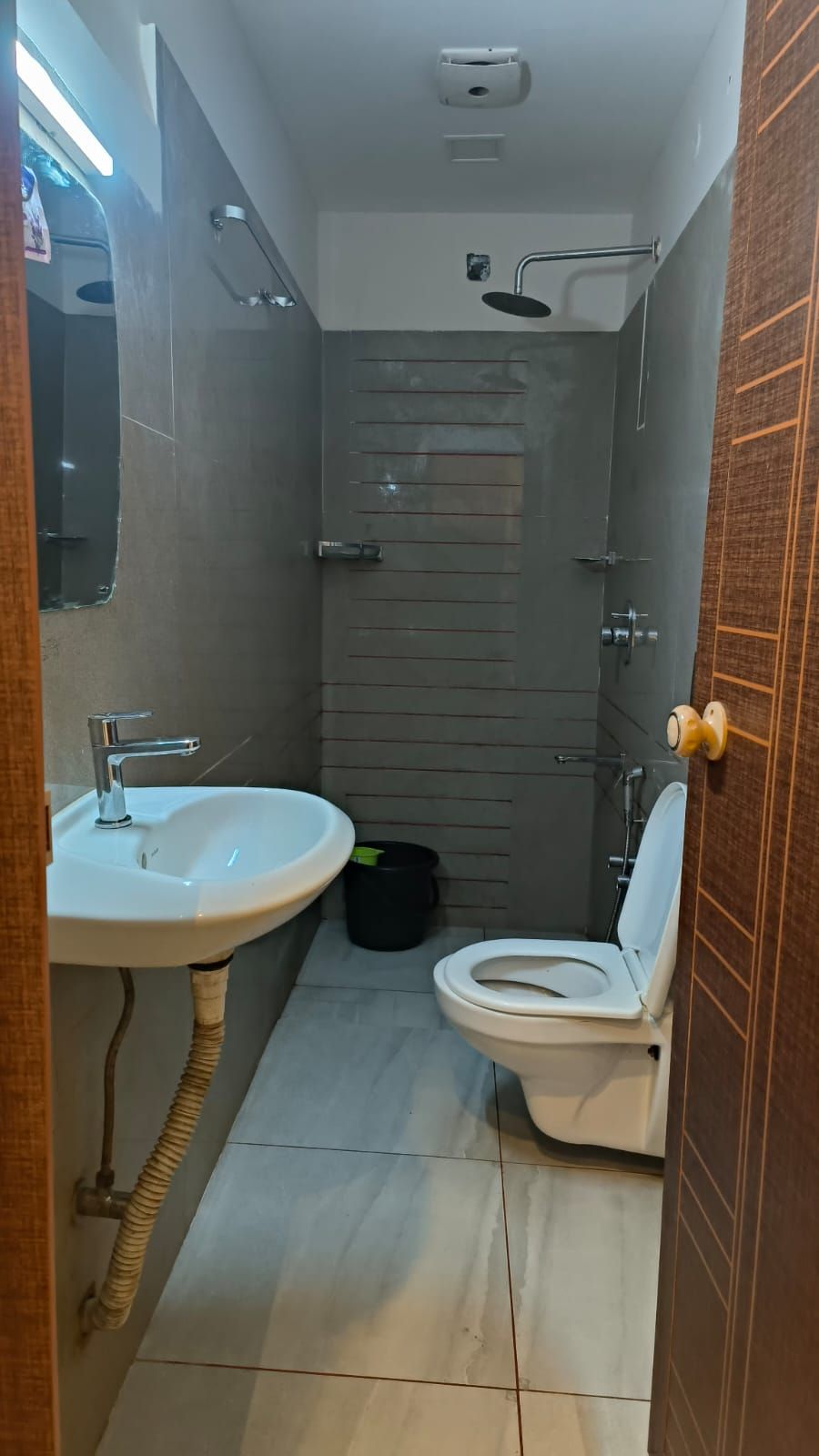 A compact bathroom with a white sink, toilet, and shower.