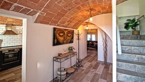 A modern kitchen with a brick ceiling, a dining area with a bench, and a staircase with stone steps. - Club Villamar - Kaixo is a detached Spanish villa with a private pool, garden, BBQ, spacious livi... (Calonge)