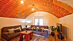 A cozy living room with a brick ceiling, a sofa set, a coffee table, and a TV. - Club Villamar - Kaixo is a detached Spanish villa with a private pool, garden, BBQ, spacious livi... (Calonge)