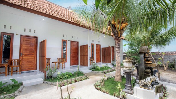 A white building with multiple wooden doors and a tiled roof. - DMY Guest House Nusa Penida (Penida Island)