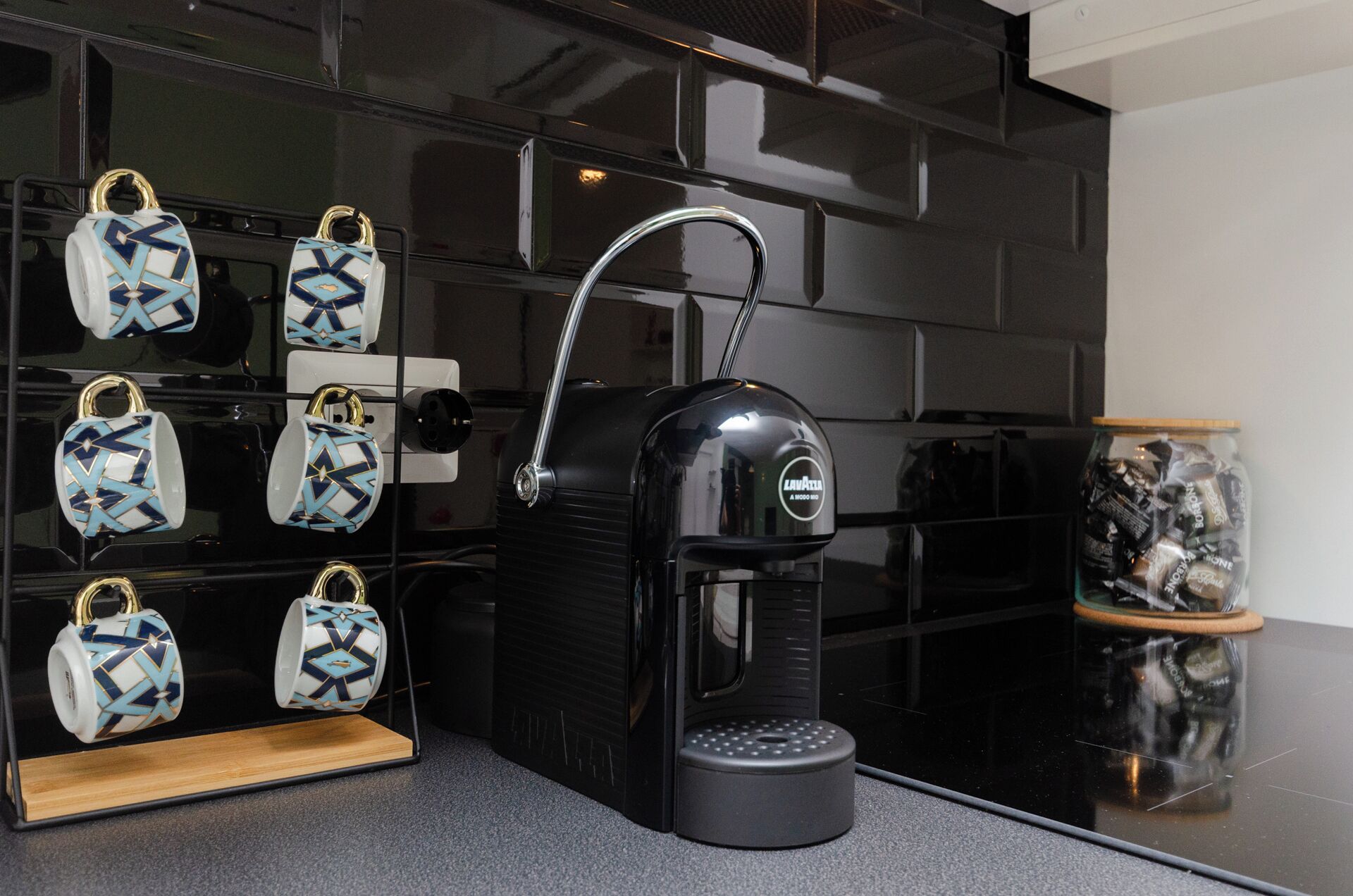 Eine Kaffeemaschine mit Wasserbehälter und einer Anzeige mit gemusterten Tassen.