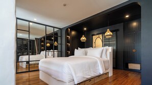 Un dormitorio moderno con una cama grande, suelo de madera y una pared espejada.