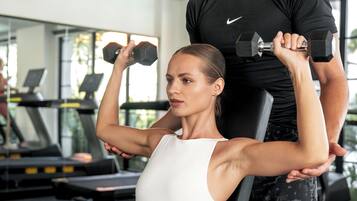 A gym with exercise equipment, including treadmills and dumbbells.