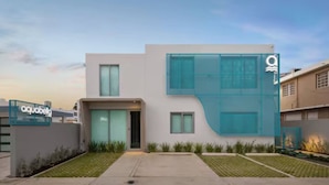 A modern building with a glass facade, a visible entrance, and a sign for 'aquabella'.