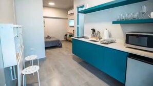 A modern kitchen with a blue countertop, a microwave, and a sink.