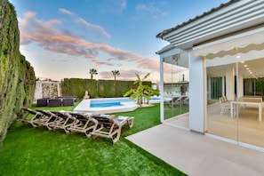 A modern house with a swimming pool, outdoor seating, and a glass-enclosed dining area. - Villa for rent in Calpe, SENIETA (Calpe)