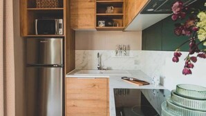 Een moderne keuken met houten kastjes, een roestvrijstalen koelkast, een magnetron en een ingebouwde oven.