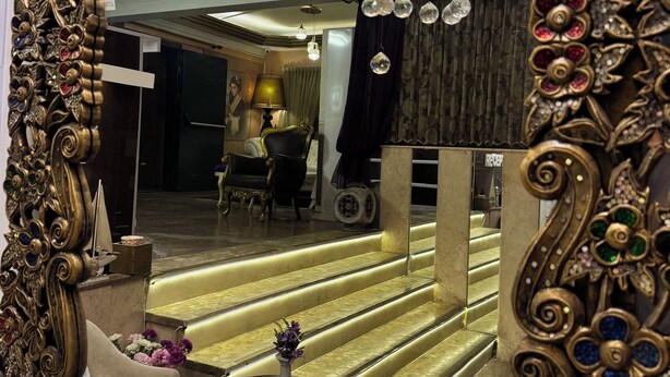 A grand mirror with ornate gold detailing and a chandelier. - Lucid Otel (Izmir)