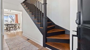 A staircase with wooden steps and black railings leading to a landing. - Mountain View Cottage | Walk to Town | Pet (Shenandoah)