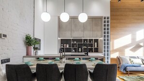 Una cucina moderna con isola centrale, luci a sospensione e pensili.