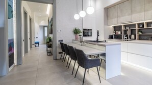 Una cucina moderna con isola centrale, illuminazione a sospensione e zona pranzo con sedie.