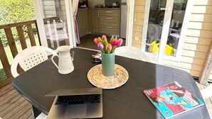 Un espace repas avec une table, un ordinateur portable et un magazine.