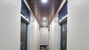 A narrow hallway with a wooden ceiling and two doors on each side. - Divy Dhaam Near Prem Mandir (Vrindavan)