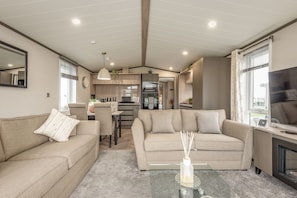 A modern living room with two sofas, a coffee table, and a TV. - Lodge No 74 | Stewart's Resort Cameron (Cameron)