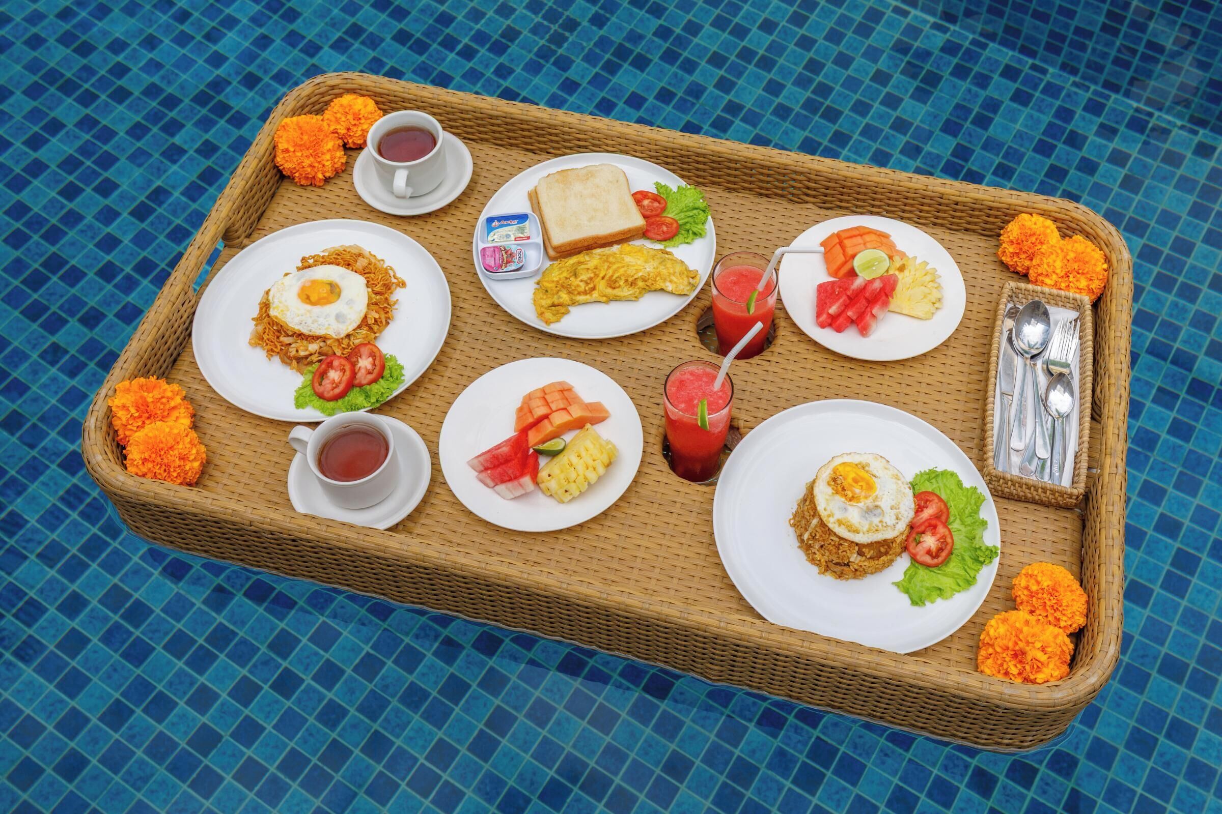 A tray with breakfast items including eggs, toast, and fruit, placed on a blue tiled surface.