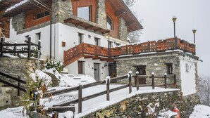 A two-story stone building with a wooden balcony and a wooden fence. - Maison Chatelard (La Salle)