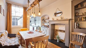 A cozy living room with a fireplace, wooden furniture, and a dining area with a table and chairs. - Host Stay Park Terrace (Whitby)