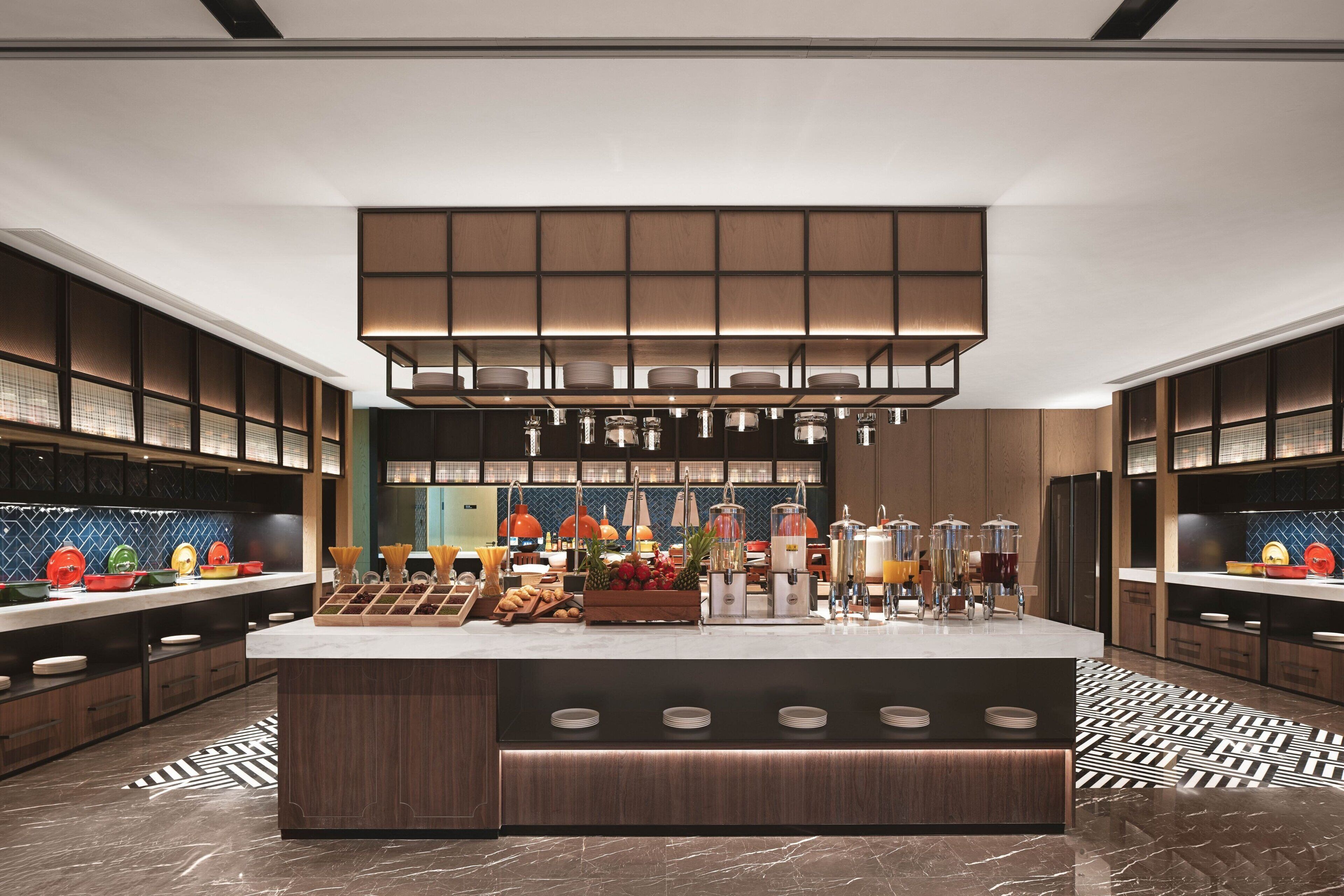 A modern kitchen with a central island, built-in appliances, and a patterned floor.