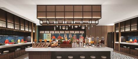 A modern kitchen with a central island, built-in appliances, and a patterned floor.