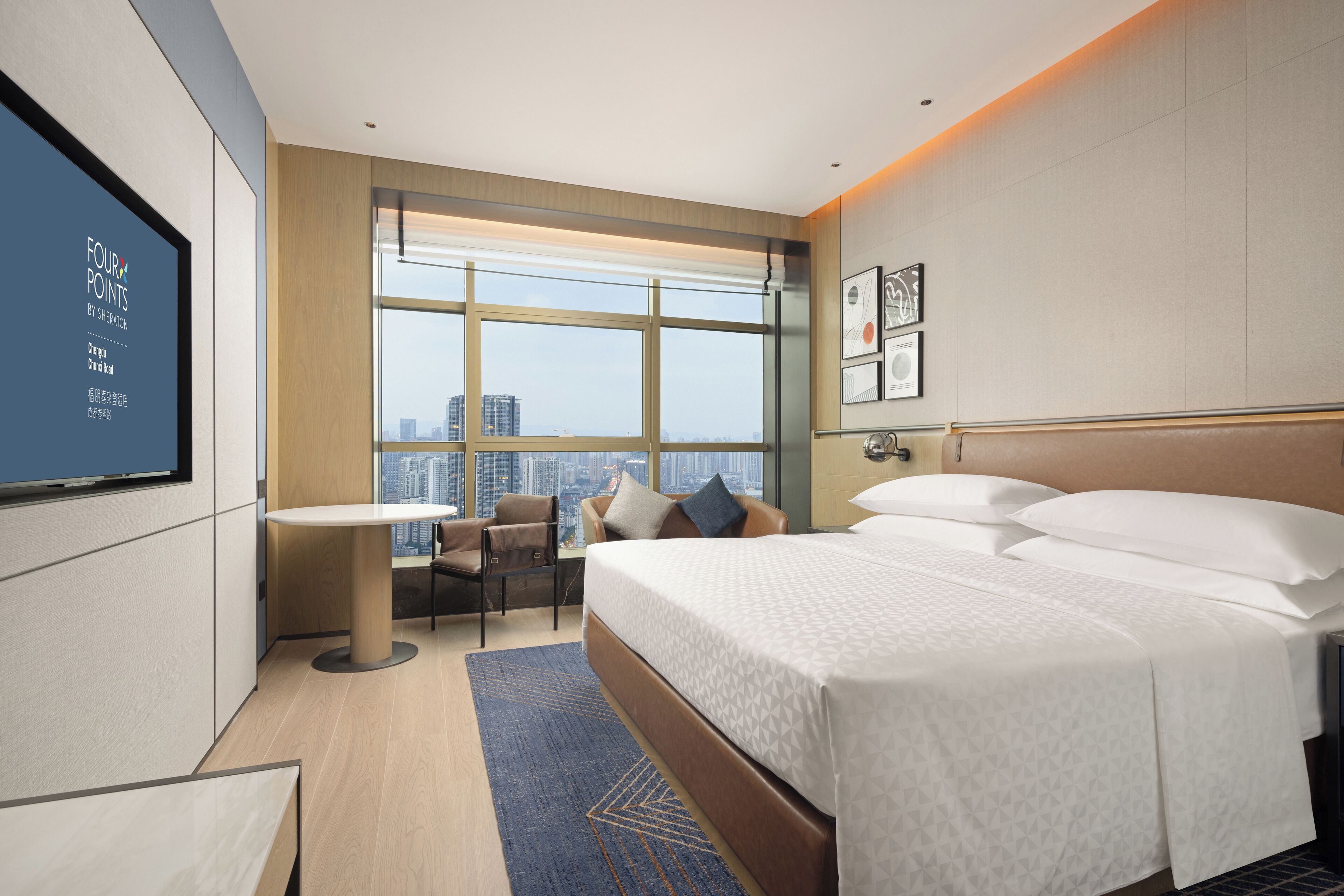 Une chambre d’hôtel moderne avec un grand lit, un bureau et une vue sur la ville.