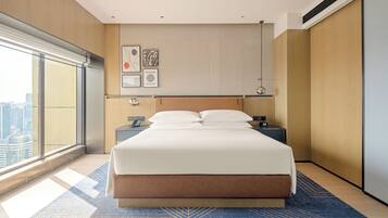 Habitación de hotel moderna con una cama grande, vistas a la ciudad y una decoración minimalista.