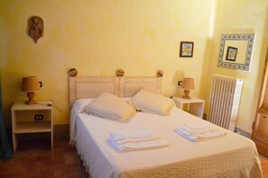 Cozy bedroom with a large bed, bedside tables, and warm decor.