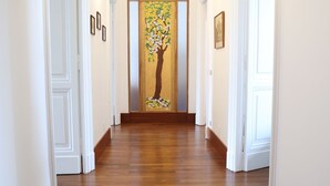 A hallway with wooden flooring, white walls, and framed pictures. - DOMUS HORTENSIA AT THE VATICAN (Roma)