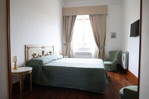 Une chambre à coucher avec un lit, une chaise, une table et un téléviseur.