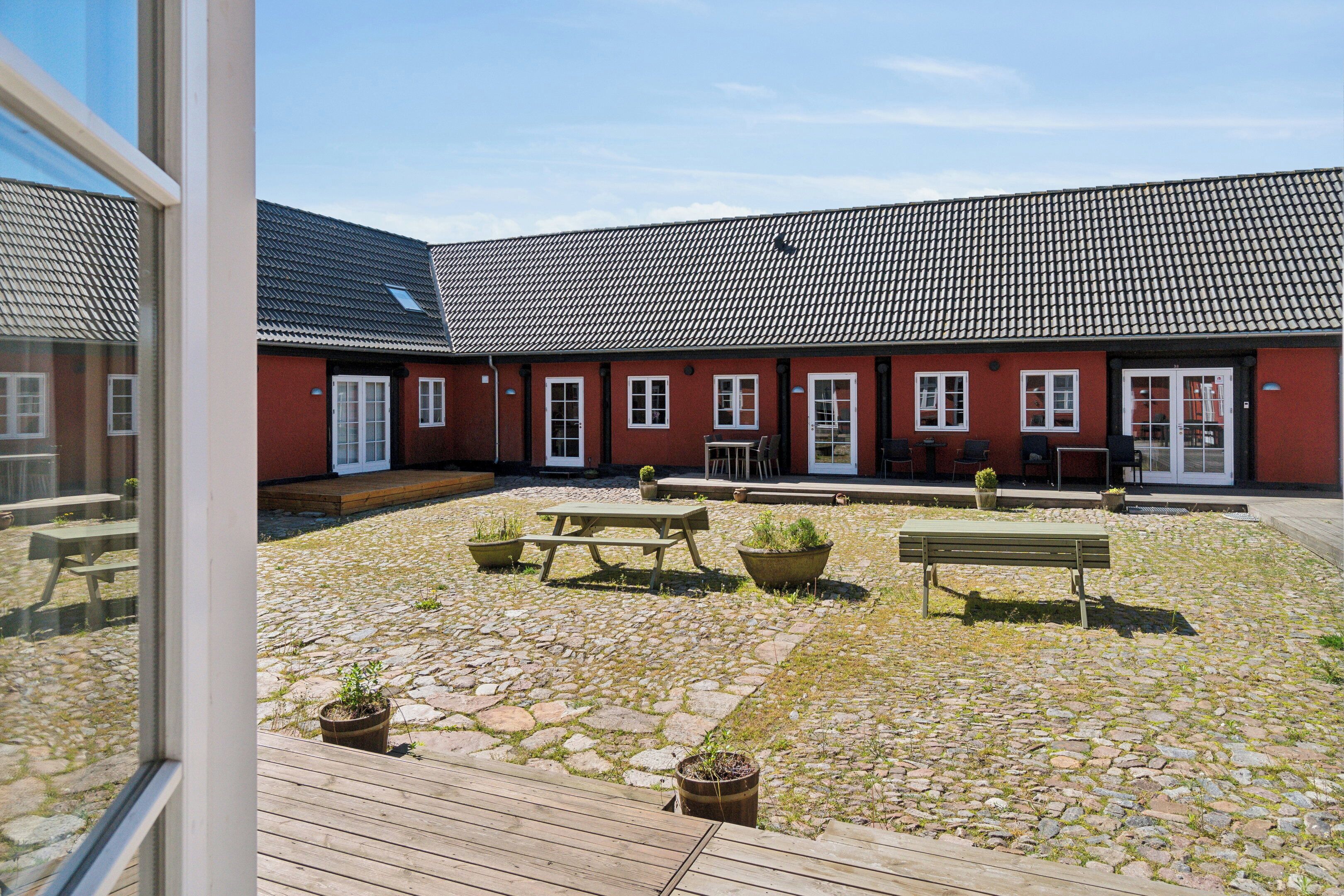 A courtyard with a wooden deck, stone paving, and outdoor seating.