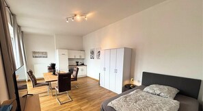 Un apartamento moderno con comedor, kitchenette y cama.