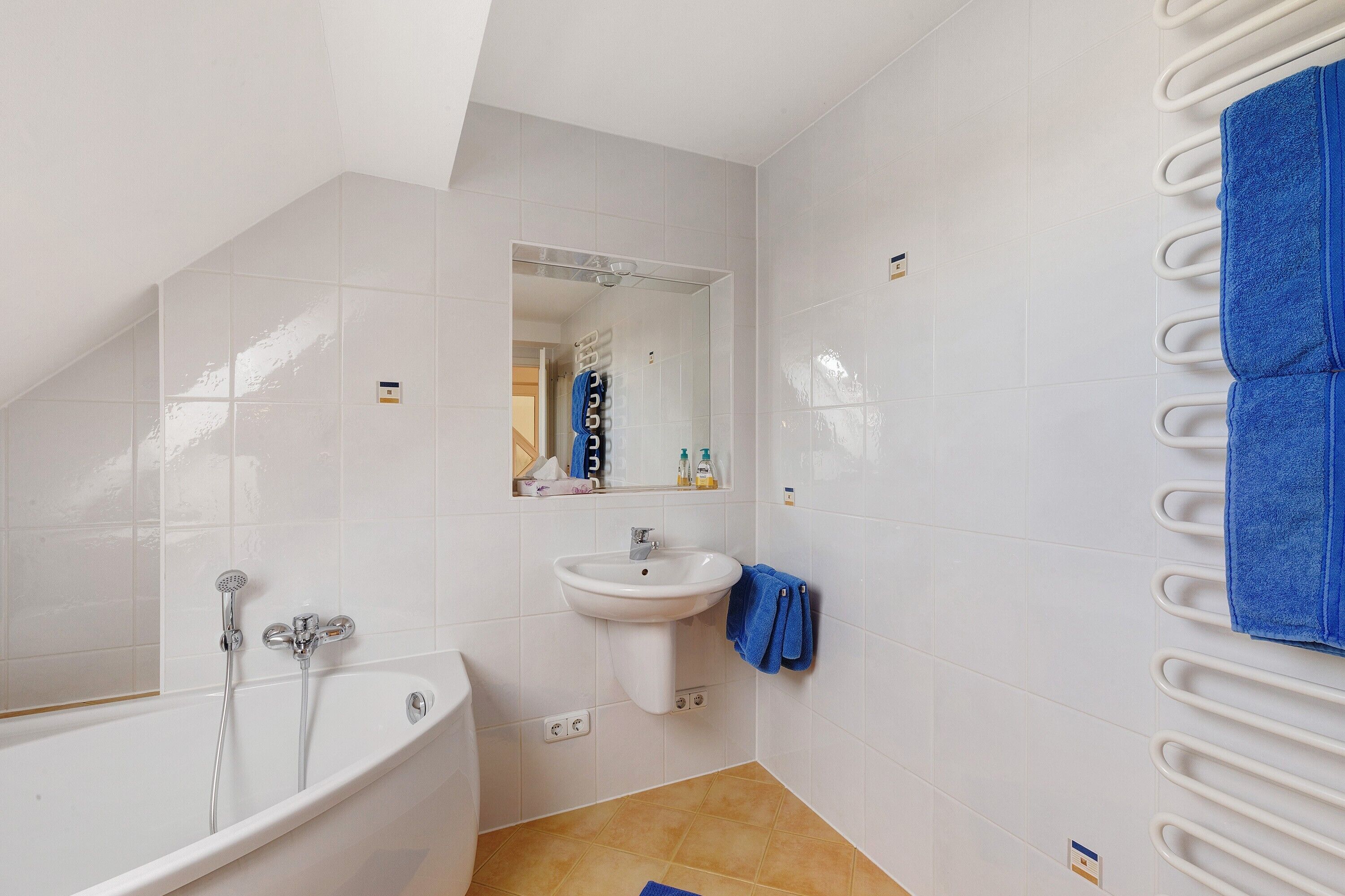 Une salle de bain avec une baignoire, un lavabo et un porte-serviettes.
