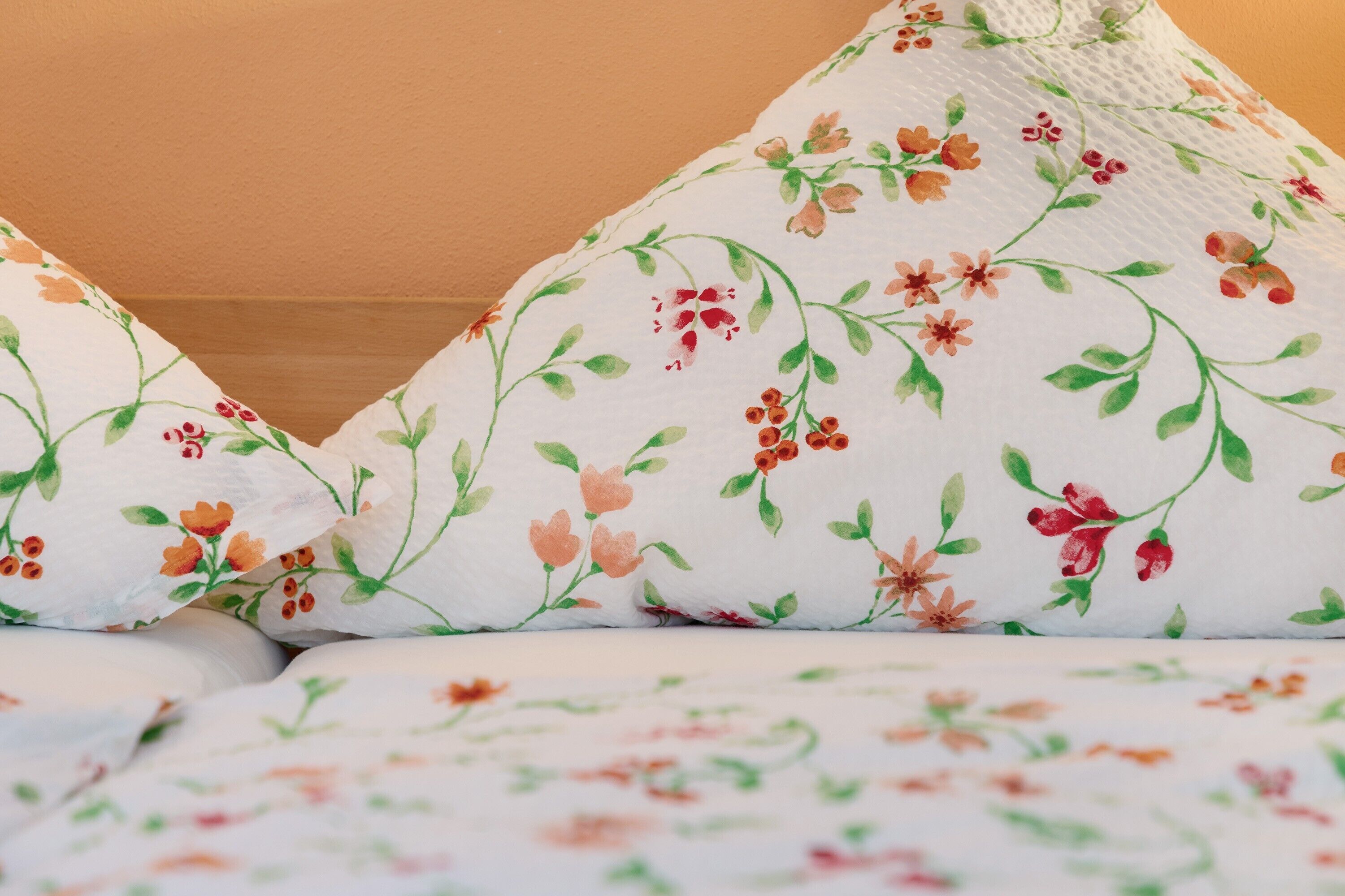 Ein Bett mit blumigem Bettzeug.