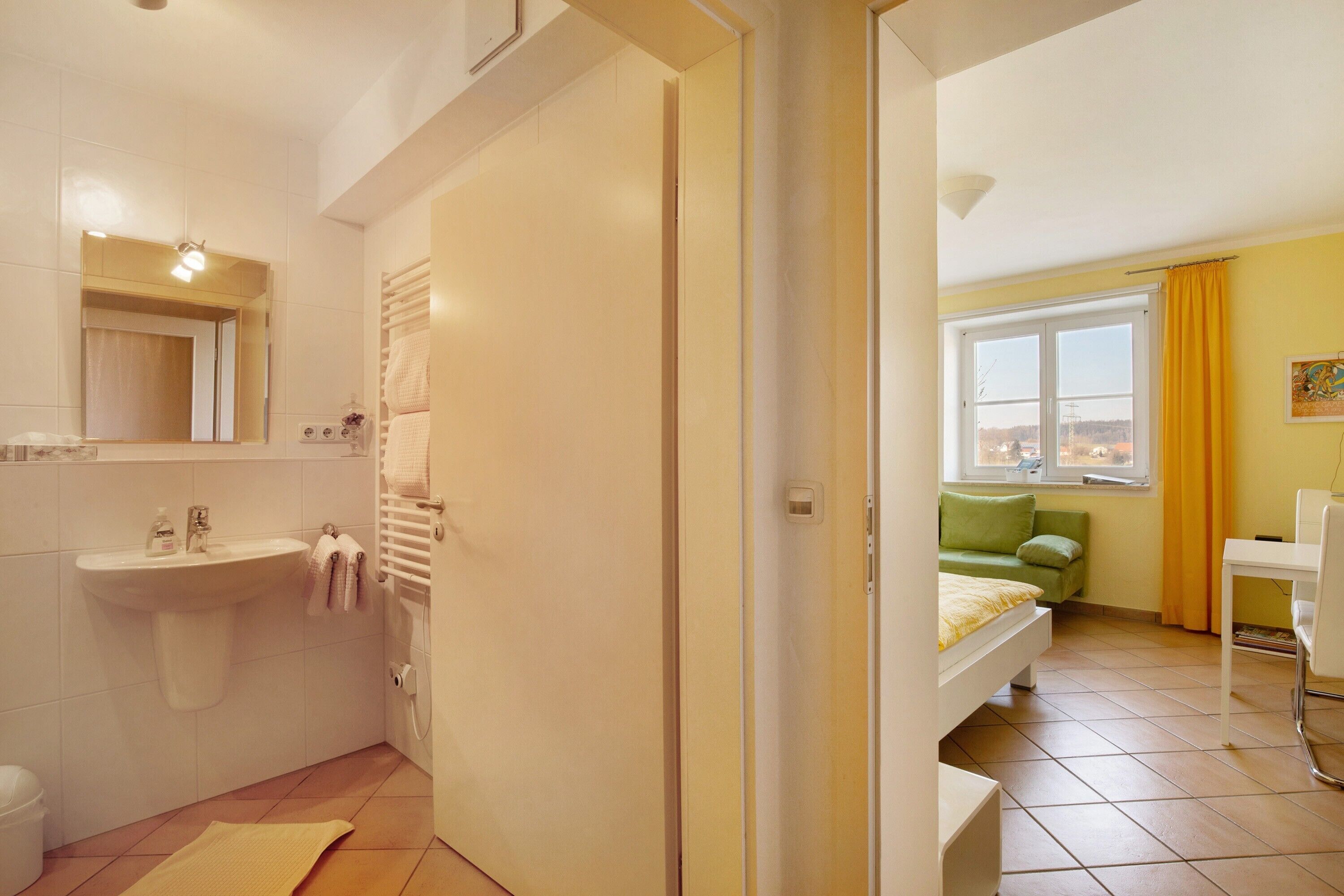 Une salle de bain équipée d’un lavabo, d’un miroir et d’un porte-serviettes.