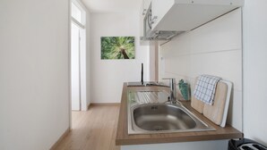 Eine moderne Küche mit Spüle aus Edelstahl, Holz Arbeitsplatte und Blick auf Grünfläche.