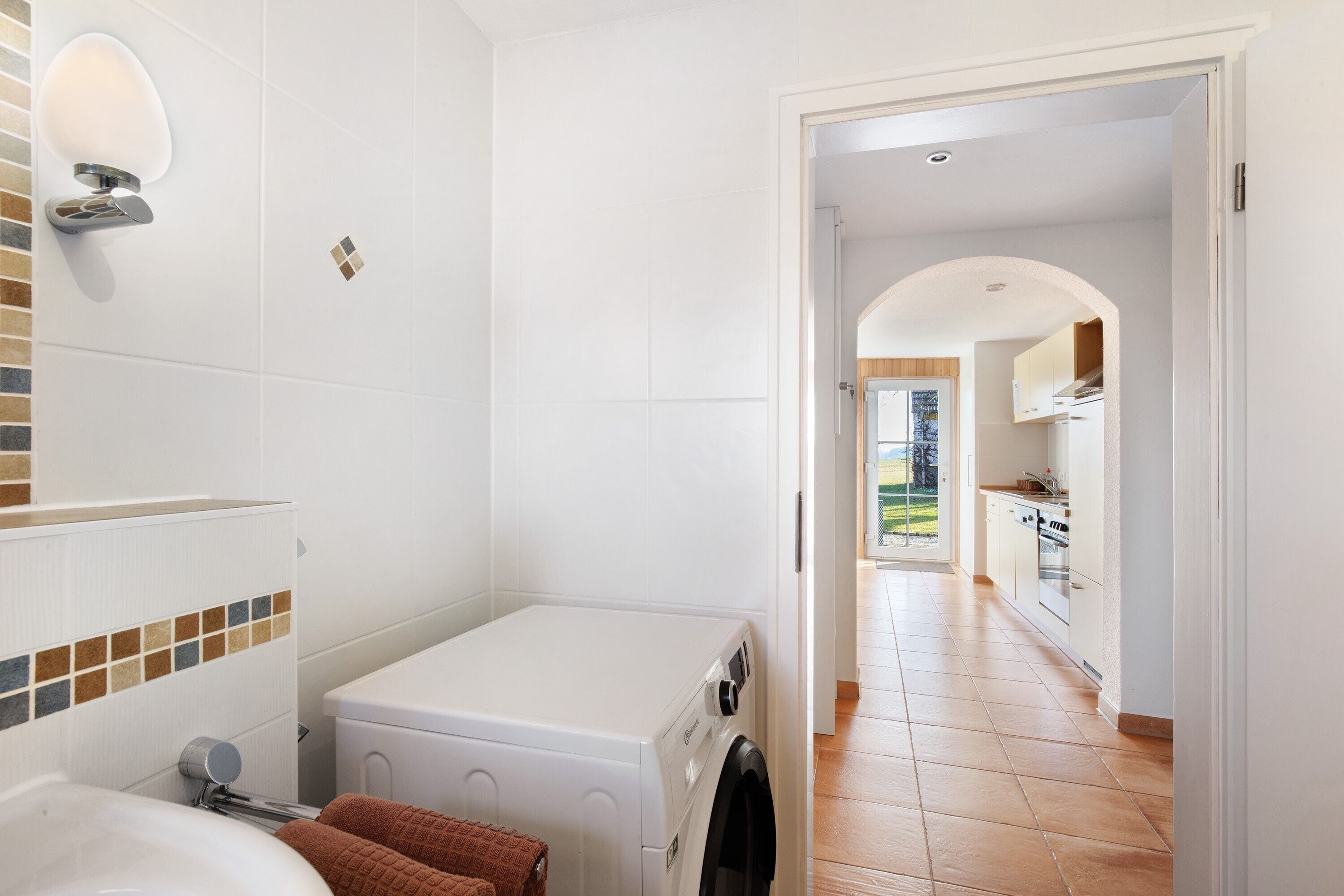 Un cuarto de lavandería con lavadora, lavabo y tendedero.