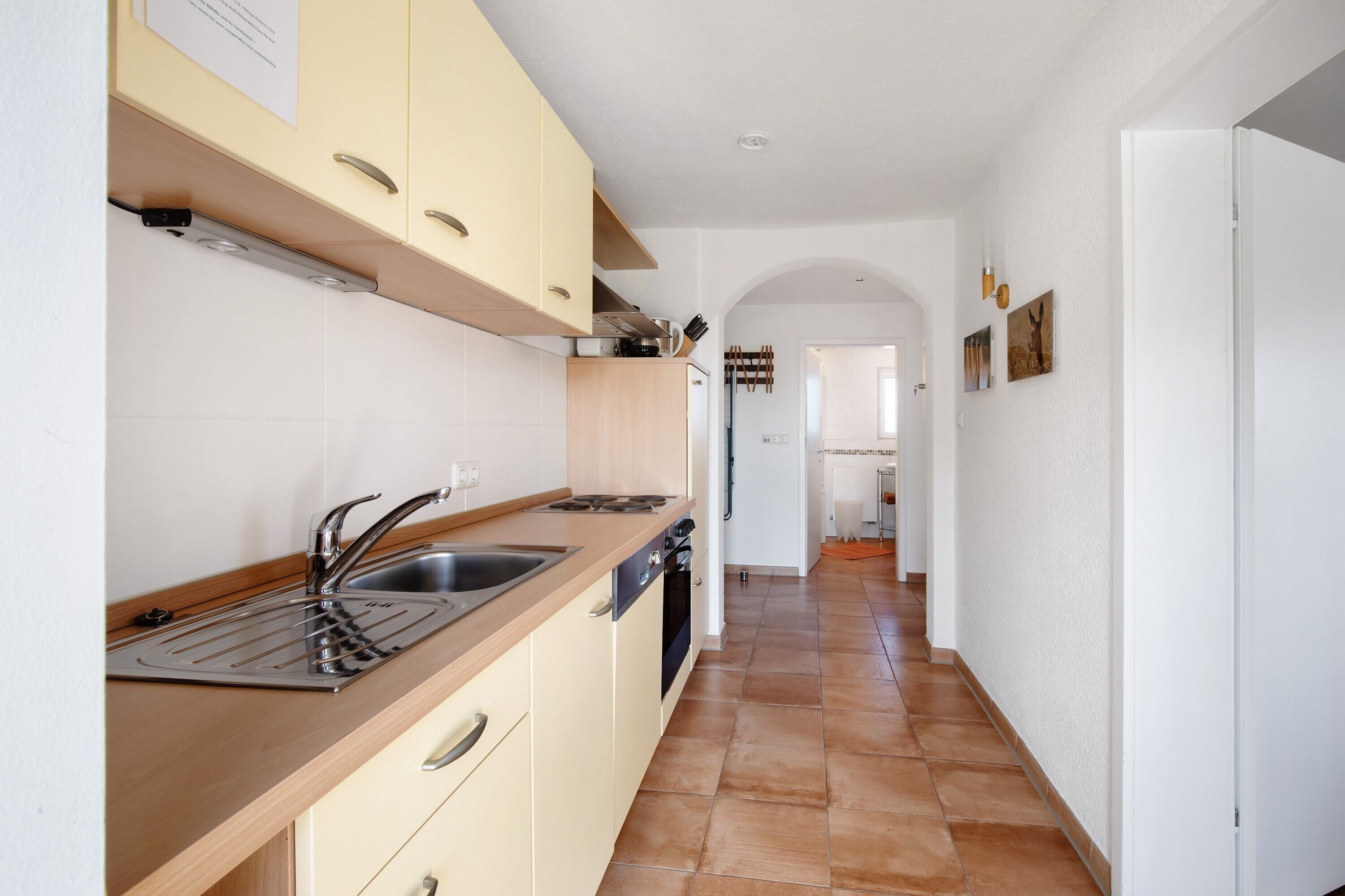 Una cocina con un lavabo, estufa y armarios.