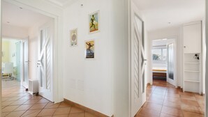 A hallway with white walls, tiled flooring, and doors leading to different rooms. There are framed pictures on the walls. - Apartment 'Birkethof Teichblick' with Mountain View, Private Terrace, and Wi-Fi (Grimoldsried)