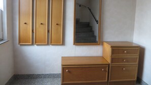 A room with a wooden dresser, a mirror, and three wooden wardrobes.