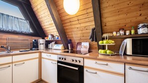 Una cocina con paredes de madera, una ventana y una variedad de electrodomésticos y utensilios.