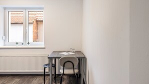 A small room with a window, a radiator, a table, and a chair. - Haus Fuldablick 'Room 3' with Shared Garden and Wi-Fi (Rotenburg an der Fulda)