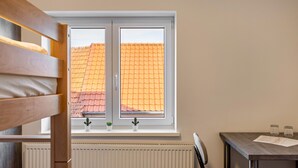A room with a window, a radiator, a table with a chair, and a bunk bed. - Haus Fuldablick 'Room 7' with Shared Garden and Wi-Fi (Rotenburg an der Fulda)