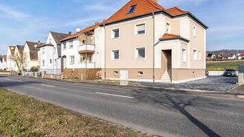 Una calle residencial con casas modernas, cielo despejado y una carretera bien conservada.