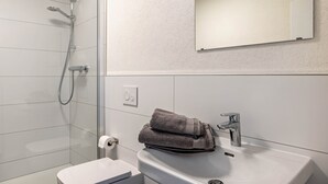 A modern bathroom with a glass-enclosed shower, a white sink, and a mirror above the sink. - Haus Fuldablick 'Room 6' with Shared Garden and Wi-Fi (Rotenburg an der Fulda)