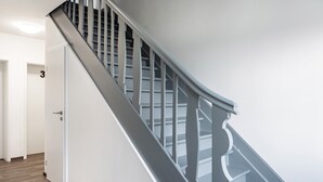 A modern staircase with a handrail and a door marked with the number 3. - Haus Fuldablick 'Room 6' with Shared Garden and Wi-Fi (Rotenburg an der Fulda)
