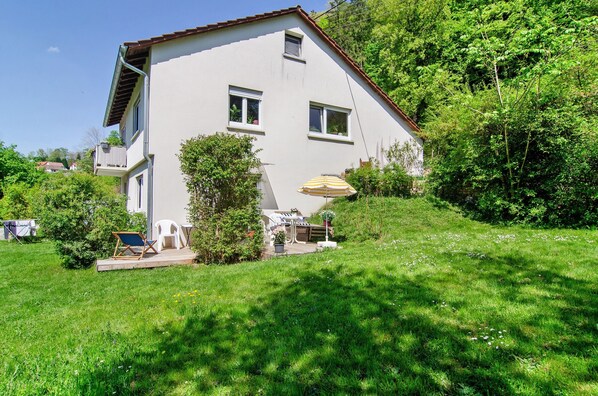 A two-story house with a balcony, a deck with outdoor furniture, and a lawn. - Apartment 'Zizi' with Mountain View, Private Terrace and Wi-Fi (Stockach)