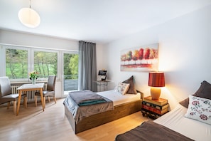 Un dormitorio moderno con cama, mesita de noche, lámpara y un cuadro.