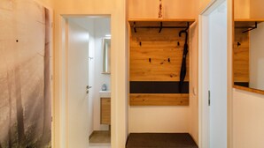 A hallway with a wooden bench, a coat rack, and a mirror on the wall. - Apartment 'Wolke8' with Private Sauna, Stunning Mountain Views, Balcony, Wi-Fi, Parking (Goslar-Hahnenklee)