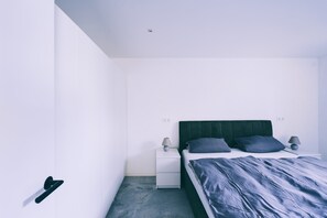 A bedroom with a bed, nightstands, and a door. - Holiday Apartment 'Haus im Weinland' with Private Terrace, Private Garden and Wi-Fi (Ihringen)